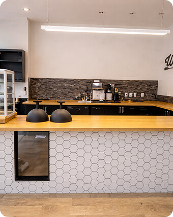 Construction workers reviewing blueprints at a building site with a crane and unfinished structure in the background.