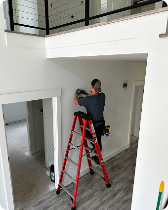 Construction worker in safety gear reviewing blueprints at a building site