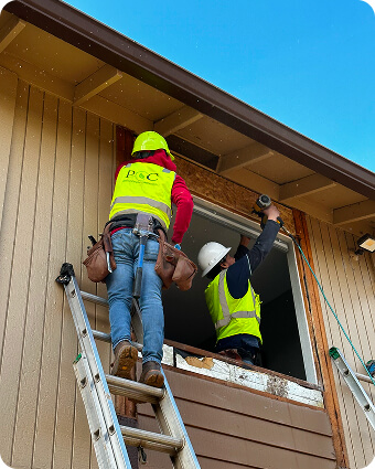 Construction worker in safety gear reviewing blueprints at a building site